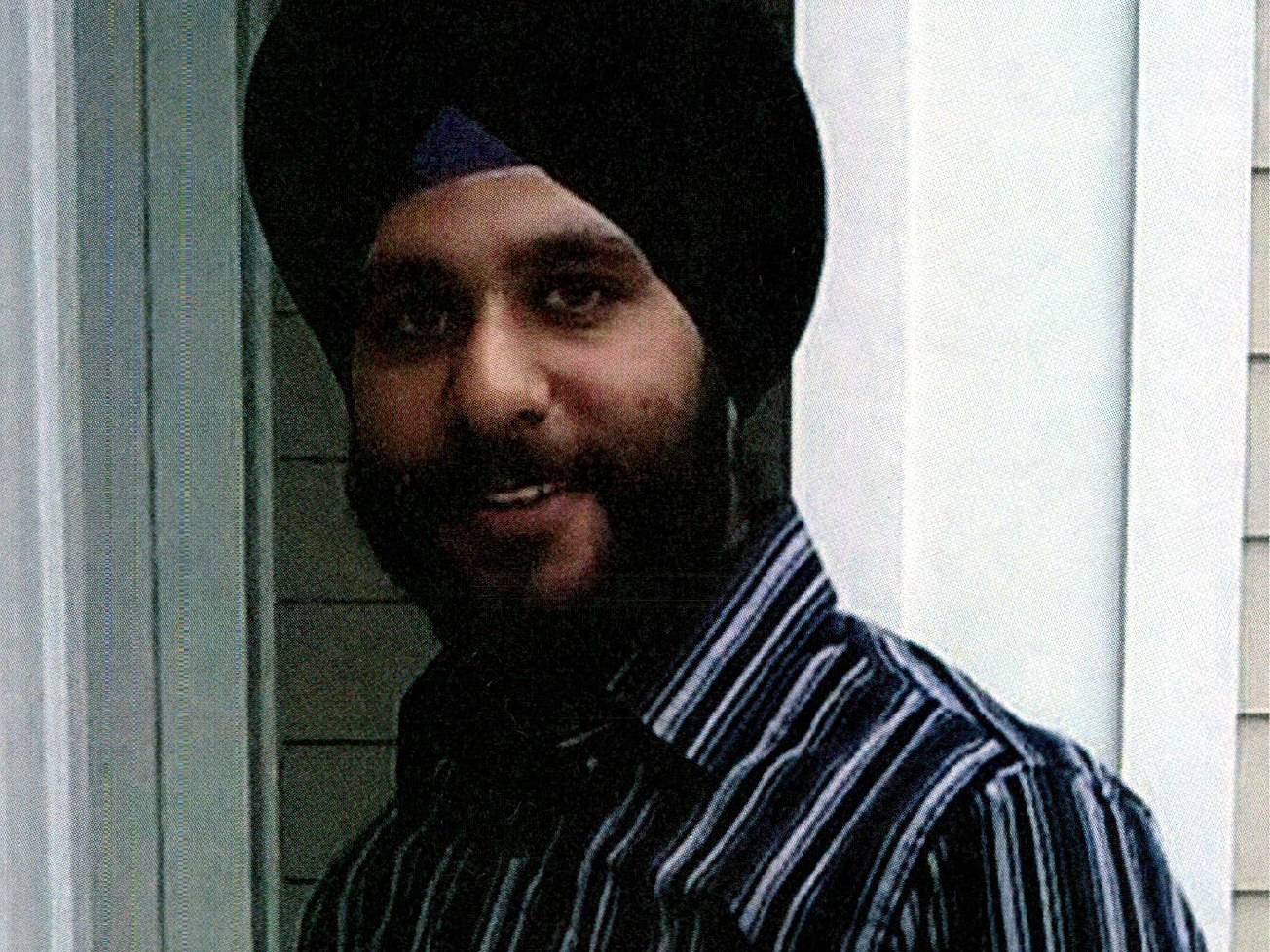 A man in a turban smiles.