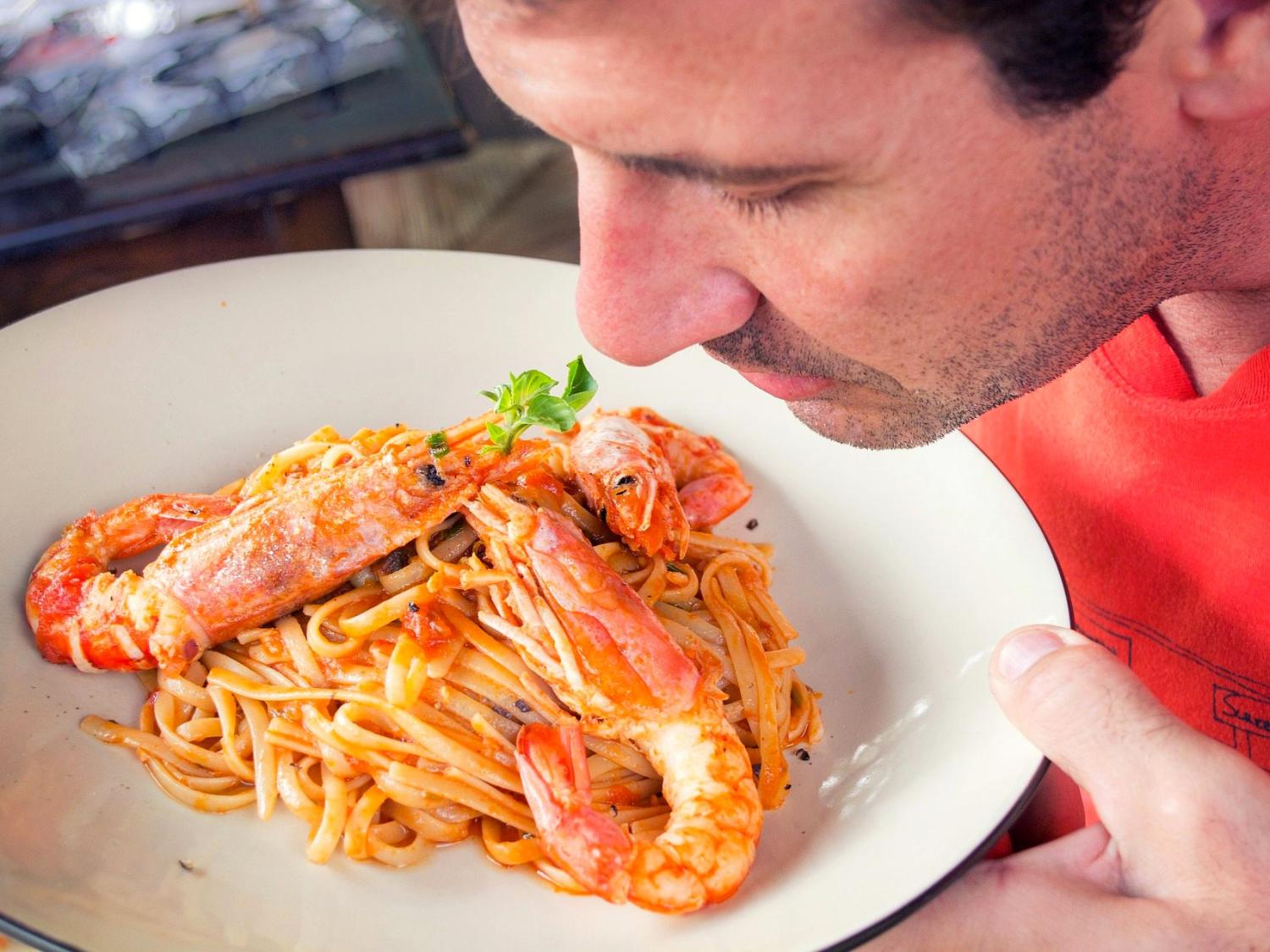 Man smelling pasta dish