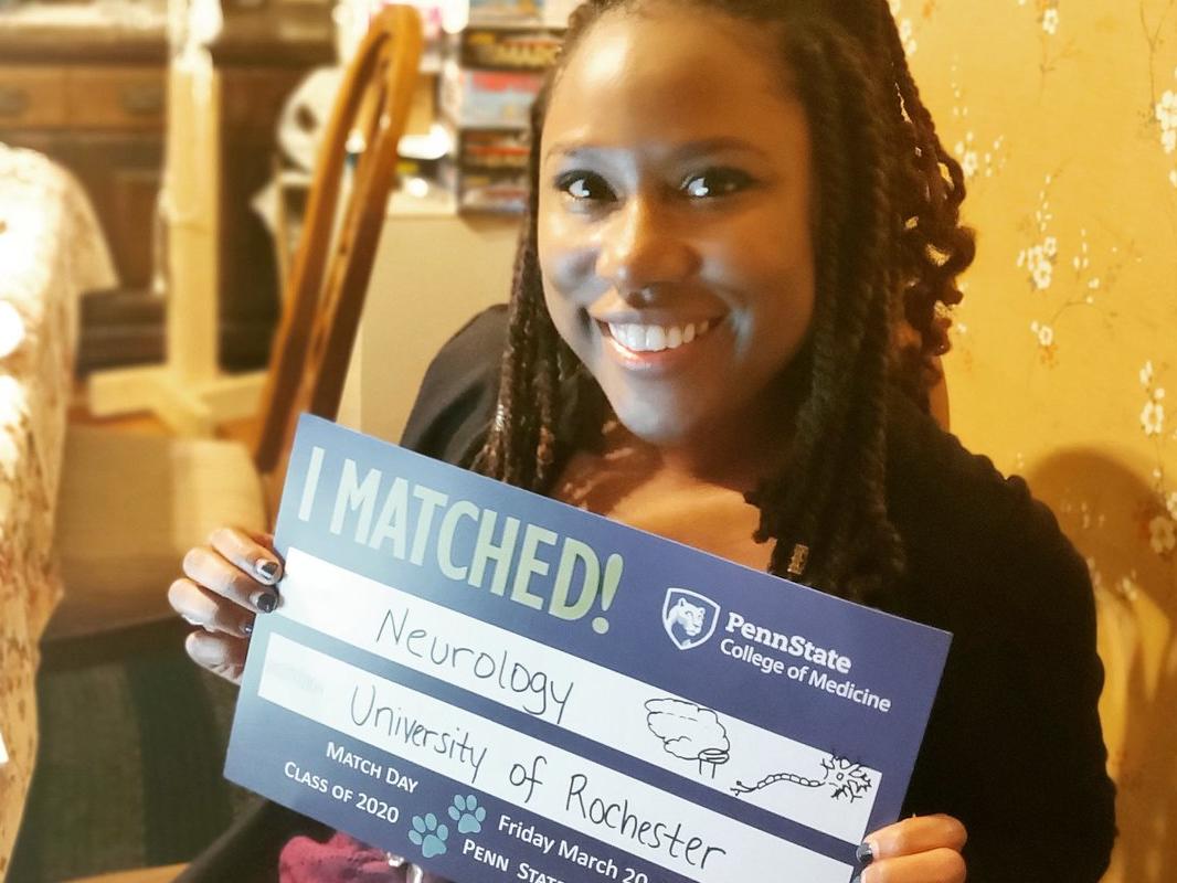 A woman holds up a sign that reads: I matched! Neurology; University of Rochester