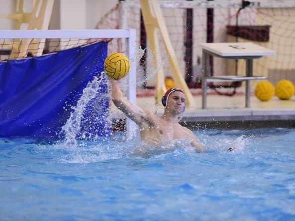 A Penn State Behrend water polo player throws the ball
