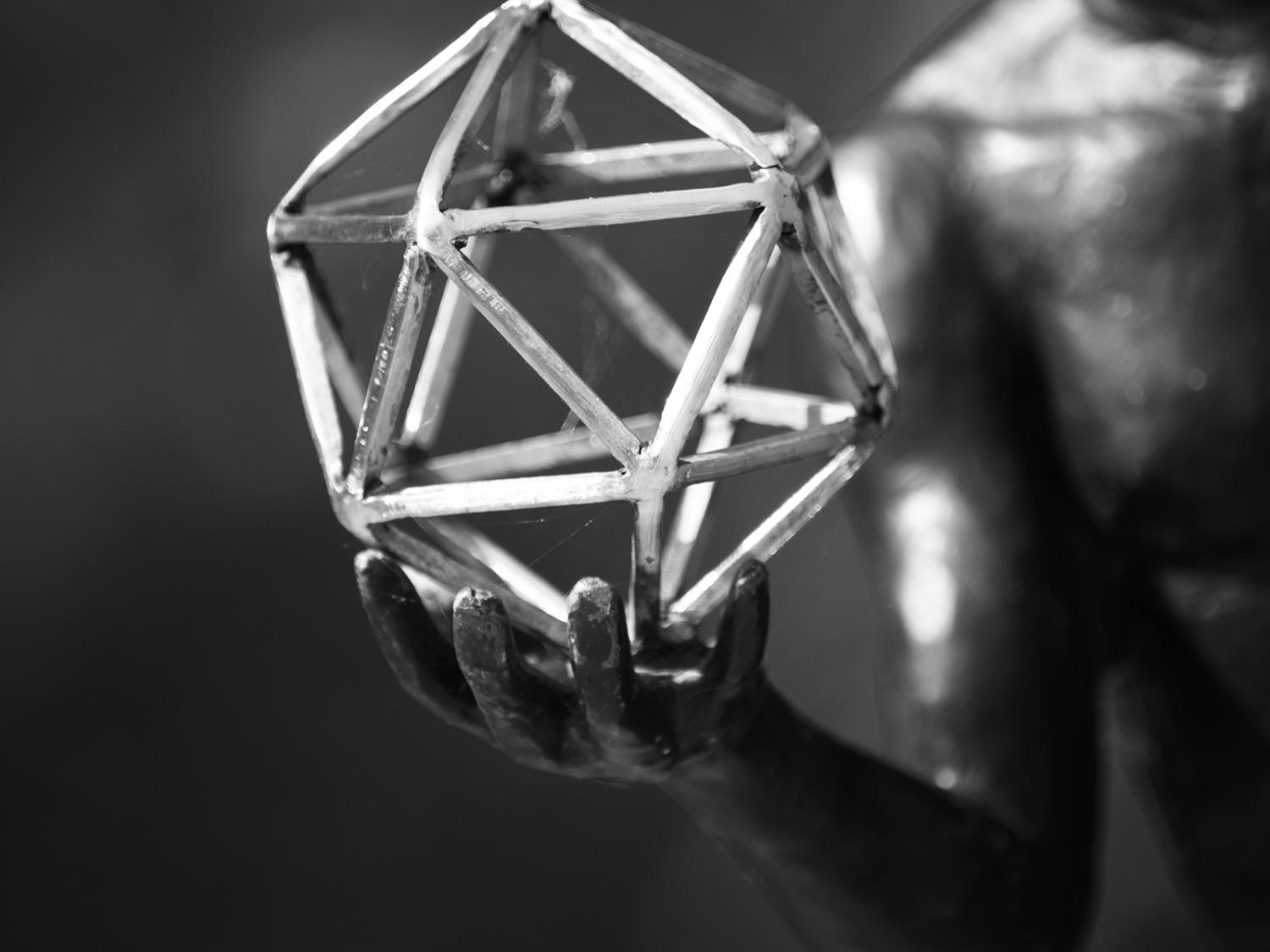 black and white image of sculpture hand and geometric figure