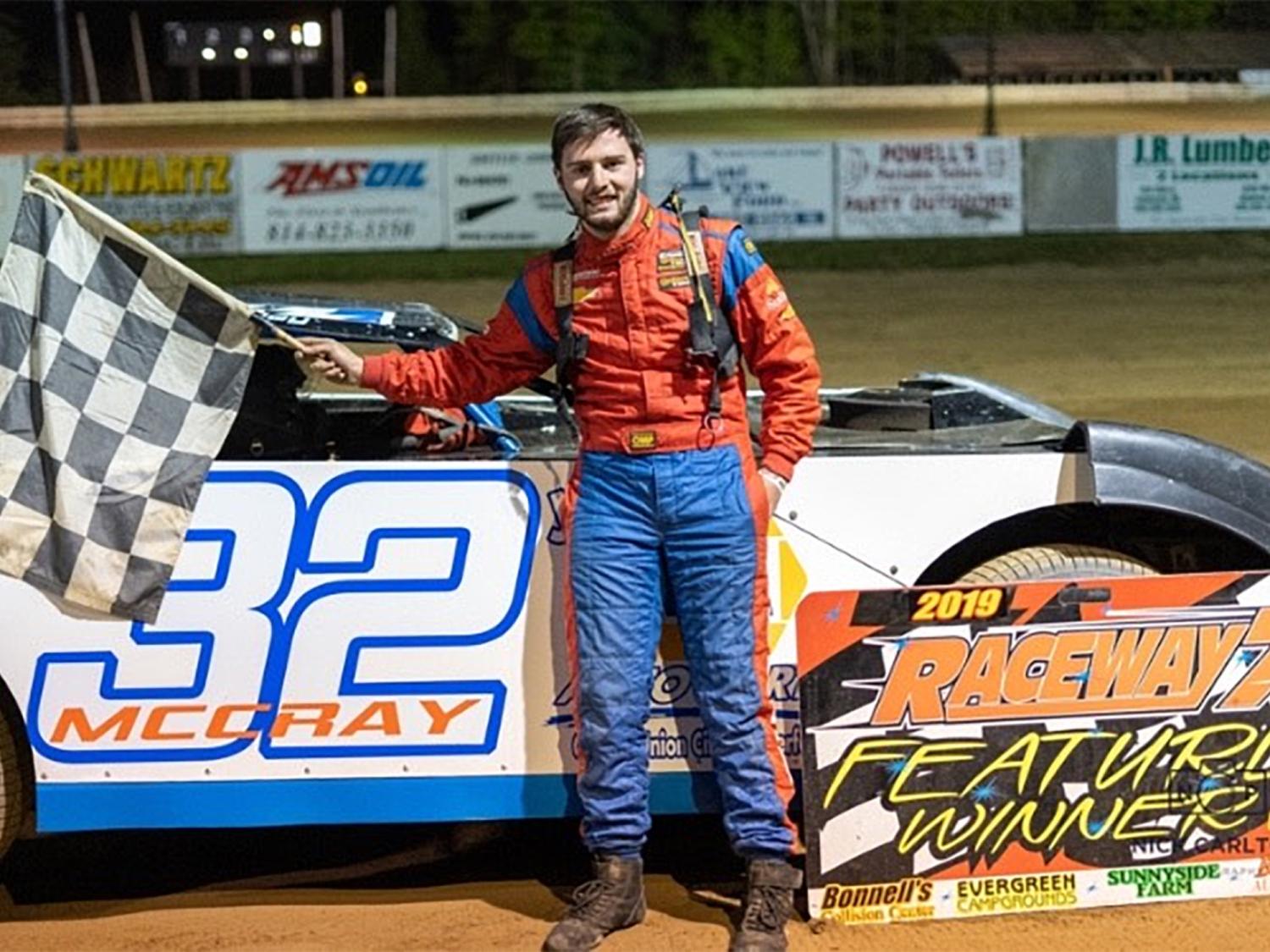 Wesley S. McCray standing beside a race car