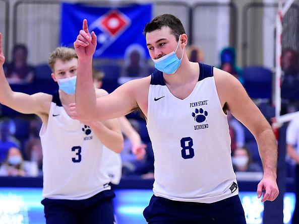 Two members of the Penn State Behrend men's volleyball team celebrate after winning a point.