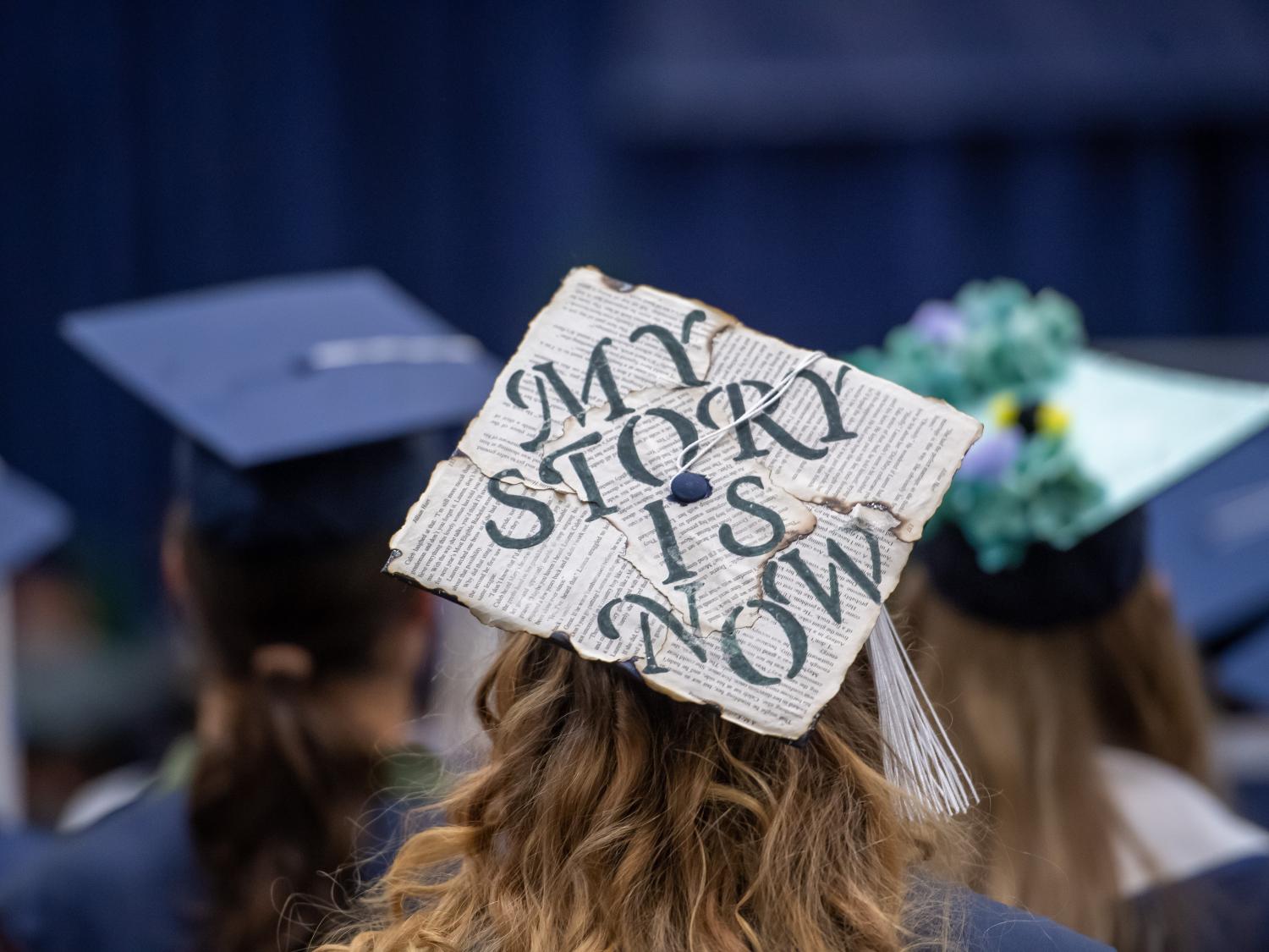 A close-up of a decorated mortarboard cap during a Penn State Behrend commencement program.