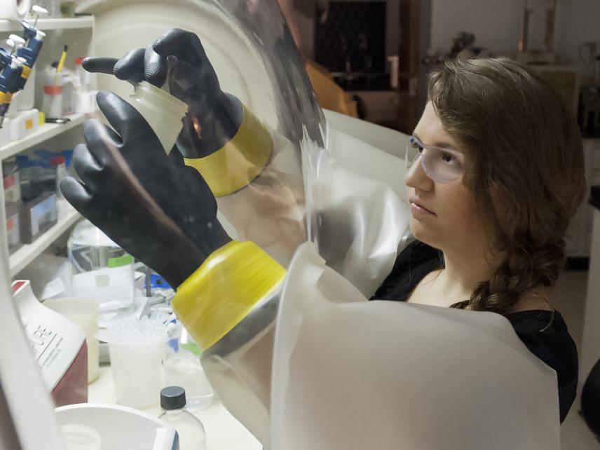 woman in protective gear measuring chemicals