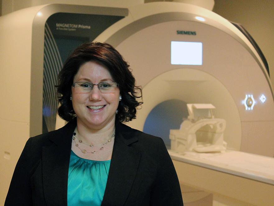 Kristina Neely, assistant professor of kinesiology, with an fMRI scanner at Penn State’s Social, Life, and Engineering Science Center.