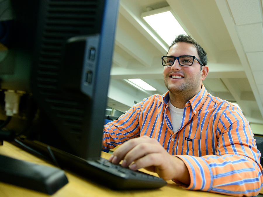Student sitting in front of desktop computer screen