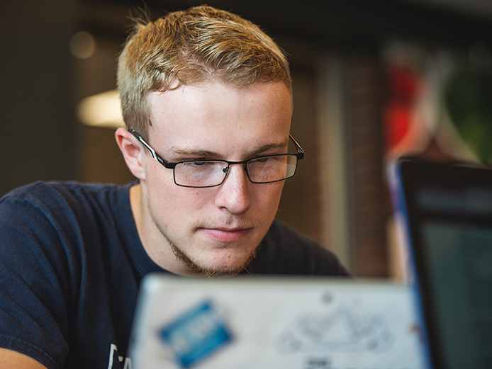 Male student looking at laptop
