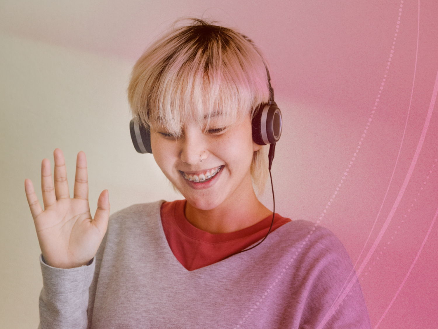 Student wearing headphones and waving hello