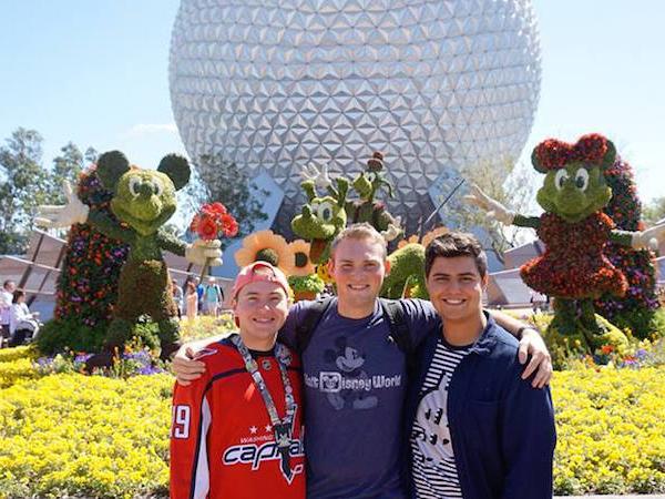 Nick Pelino and two of his roommates stand in front of a topiary display.