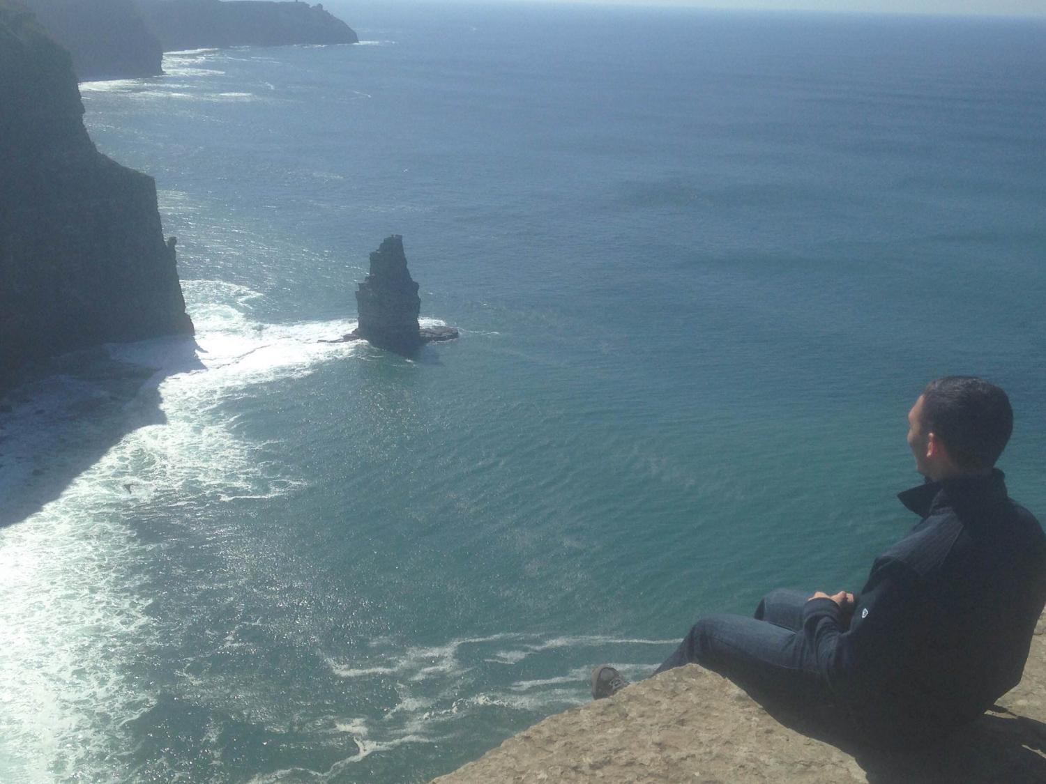 Nick Miller sits on Cliffs of Moher