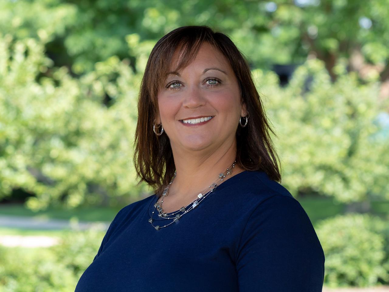 Picture of woman outside with trees in background