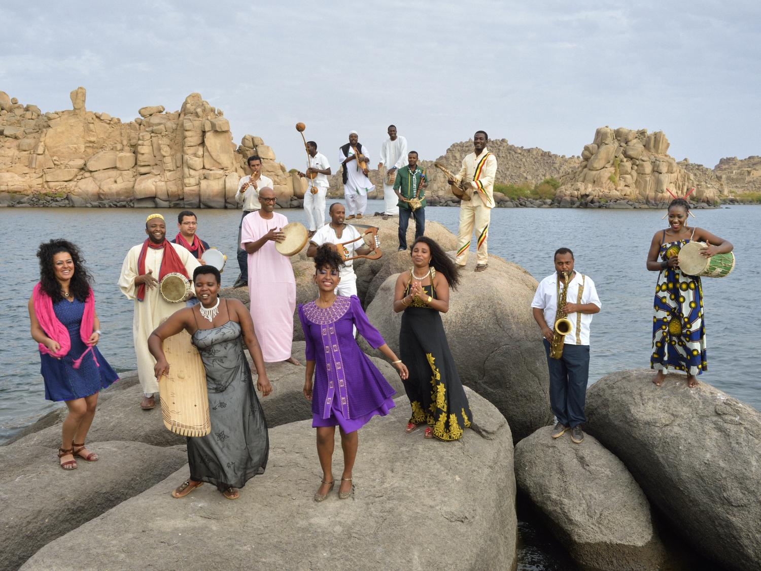 Nile Project musicians on rocks along the river