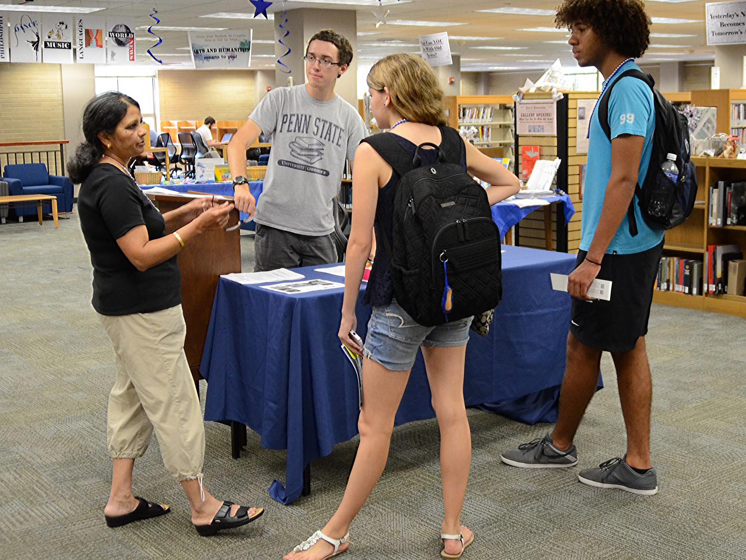 image of people standing around a table discussing available resources and servies