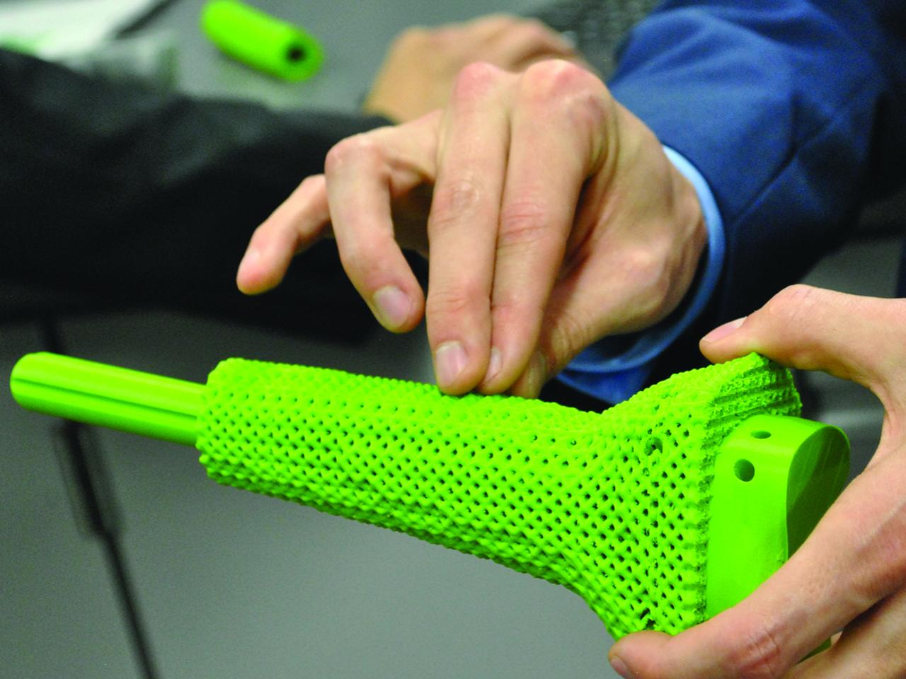 student holding 3-d model of orthopedic implant