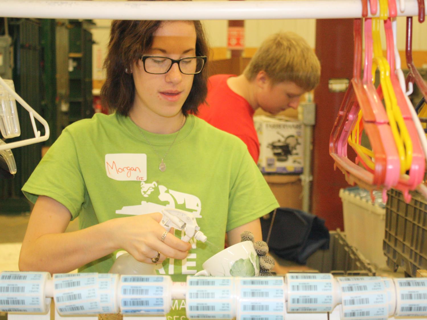 Freshman Morgan Young, of Clearfield, cleans and labels items for sale in Goodwill stores 