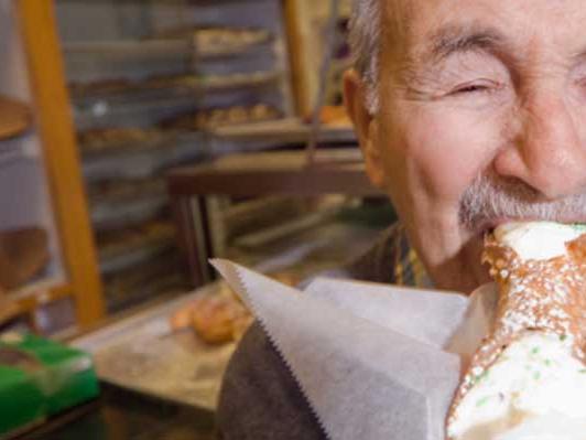 elderly man eating cannoli