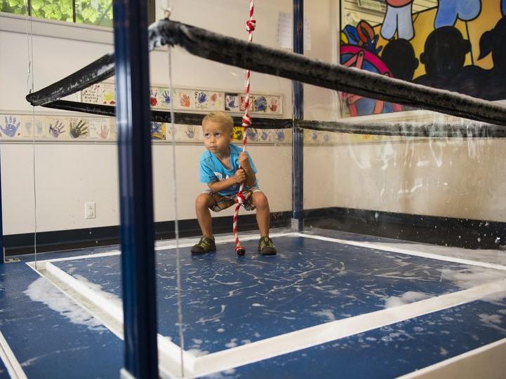 A boy tries to encase himself in a giant bubble at the ExpERIEnce Children's Museum