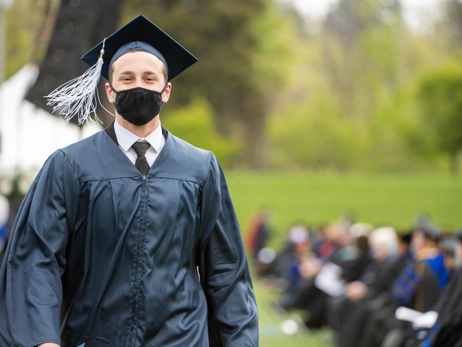 A Penn State Behrend graduate exits the commencement stage after receiving his diploma.