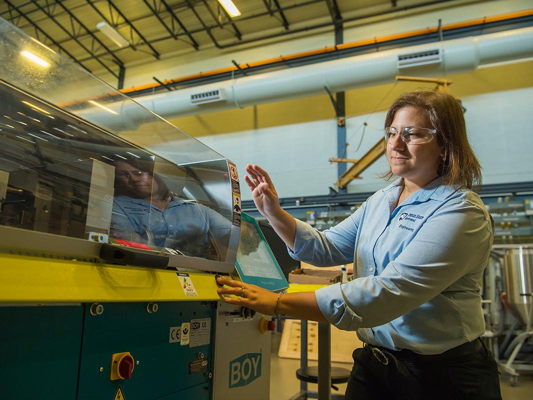 Woman operating plastics processing equipment