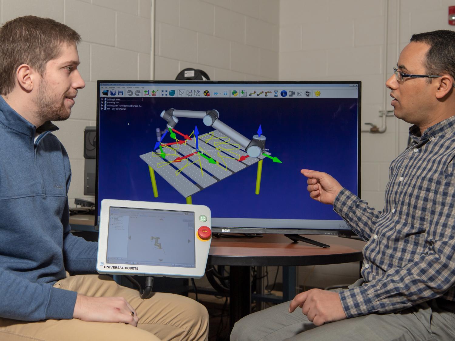 Faisal Aqlan, assistant professor of industrial engineering, uses a manufacturing simulation program while working with a student.