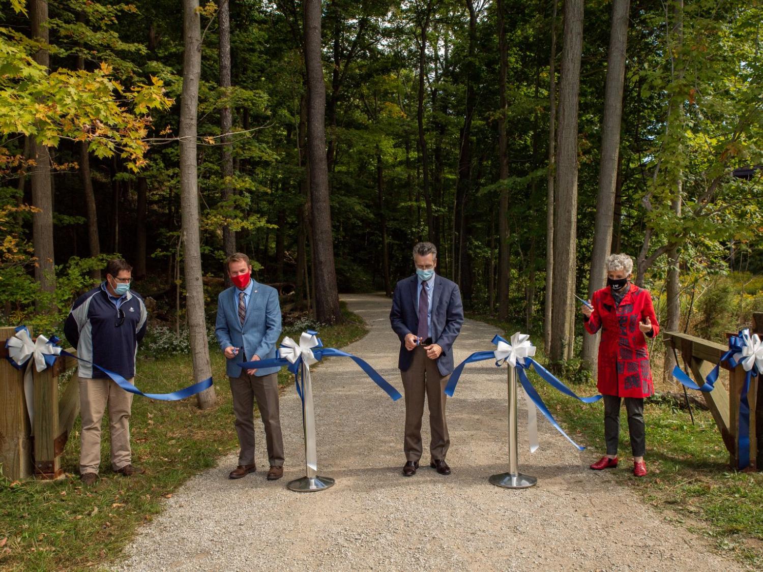Four guests cut a dedication ribbon on a Wintergreen Gorge trail.