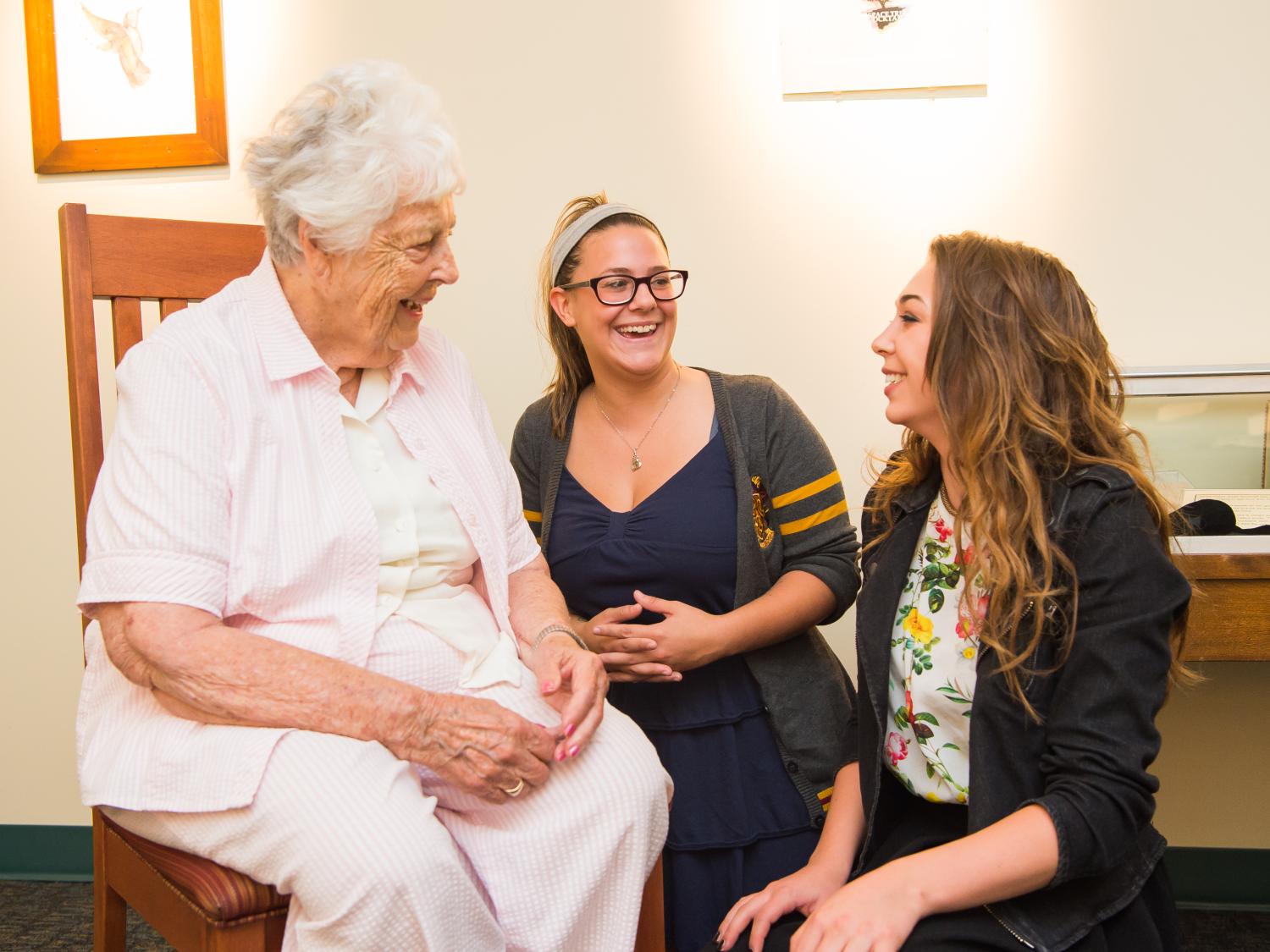 Patricia S. Yahn talks with two students in the art gallery at Penn State Behrend.