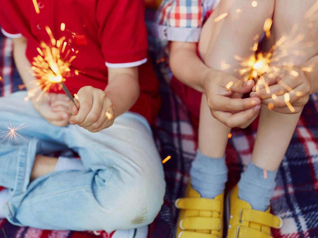 Two children with sparklers in their hands.