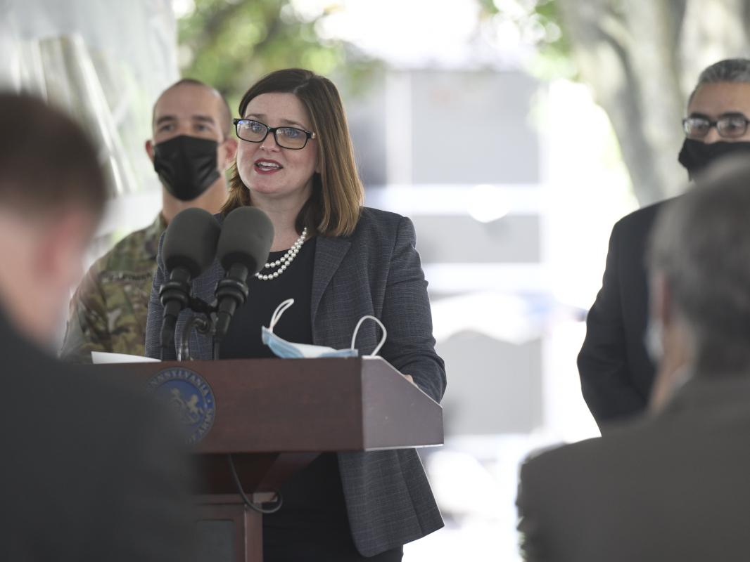 Deborah Berini, president of Penn State Health Milton S. Hershey Medical Center, speaks at a lectern as other people look on.