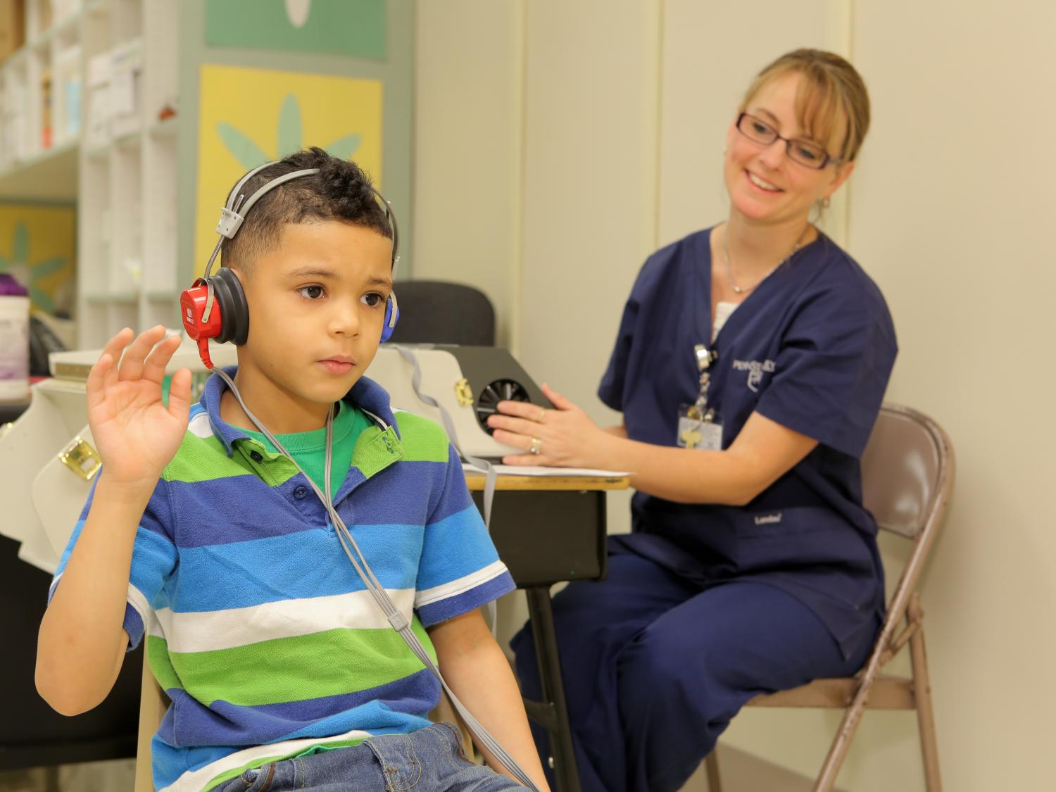A nurse administers a hearing test to a student.