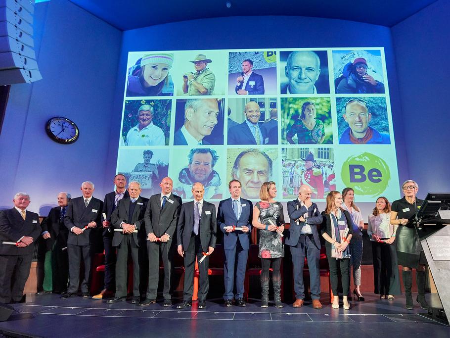 Pete Allison stands on stage with 12 other fellows