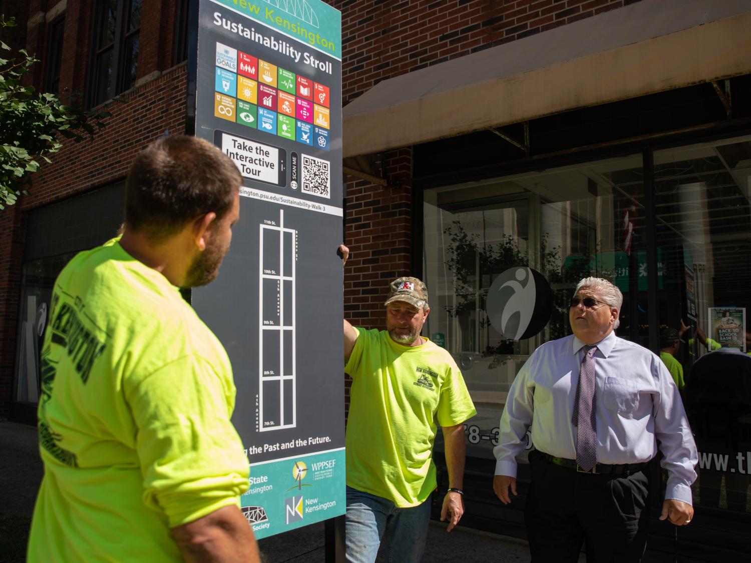 Three men look at street sign