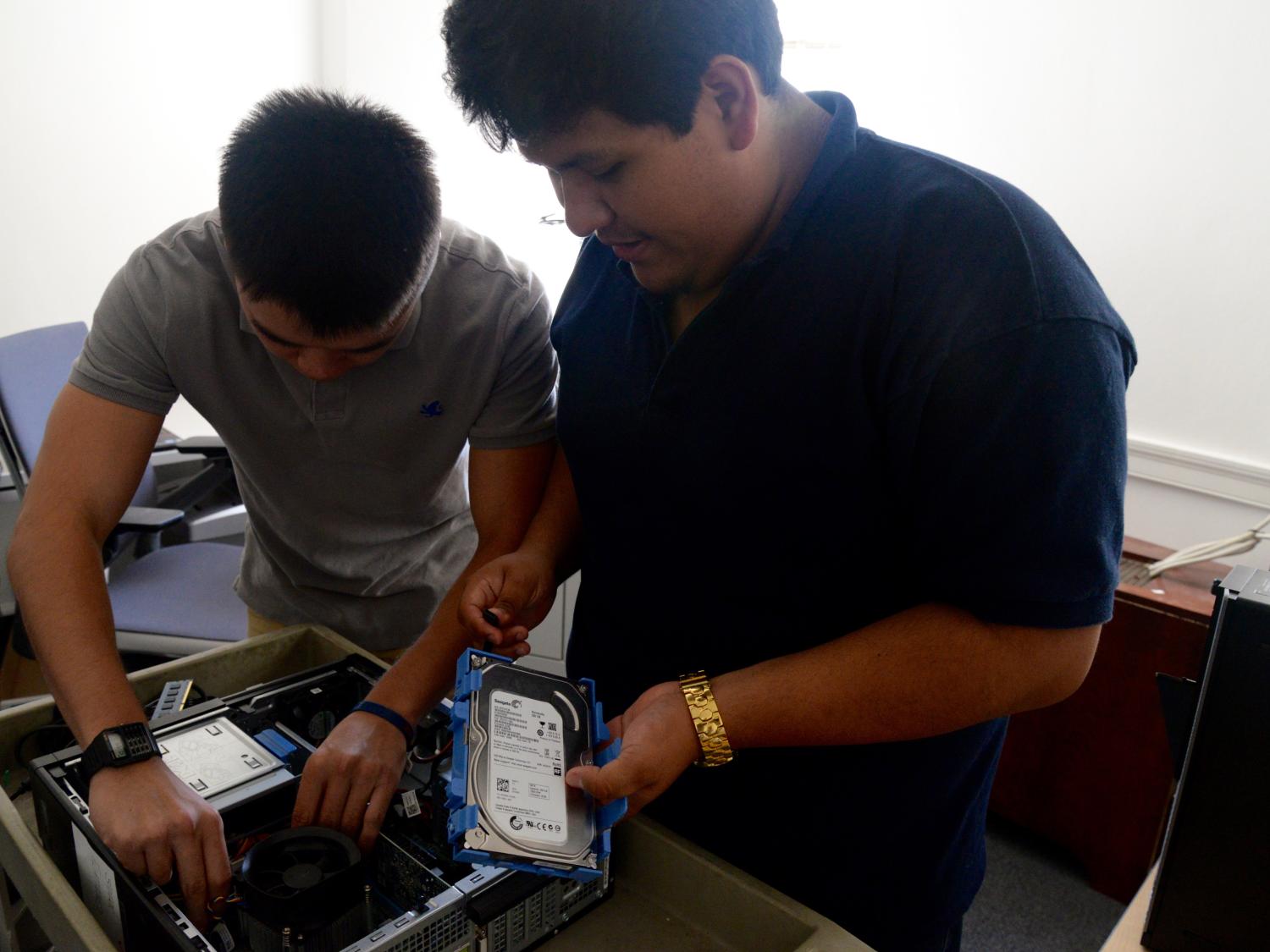 Student IT workers fix the motherboard of a computer