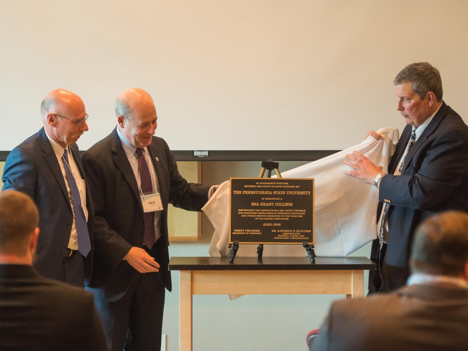 A plaque announcing Sea Grant College status for Penn State is unveiled.