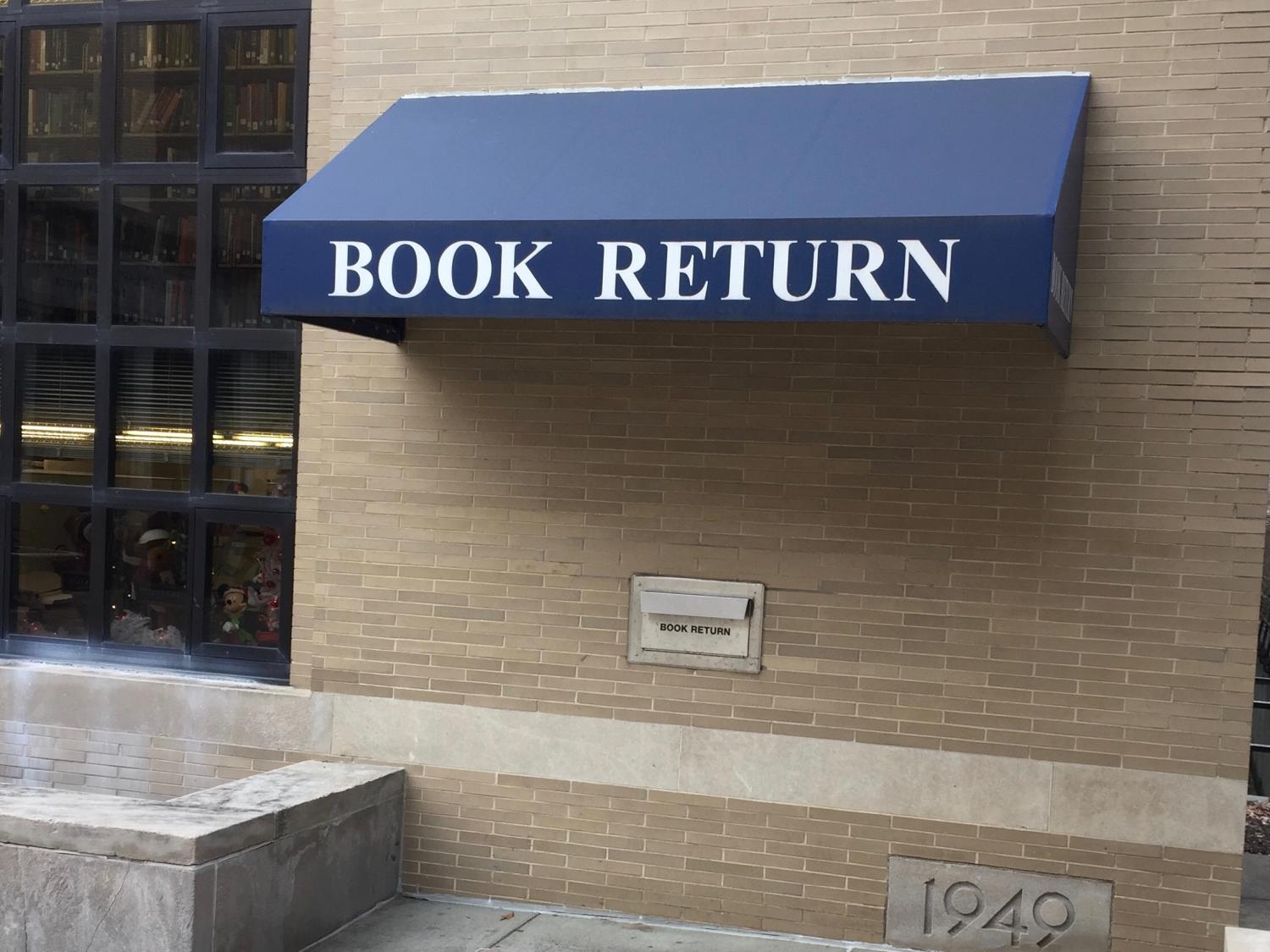 image of outside library book return slot with fabric overhang labeled book return