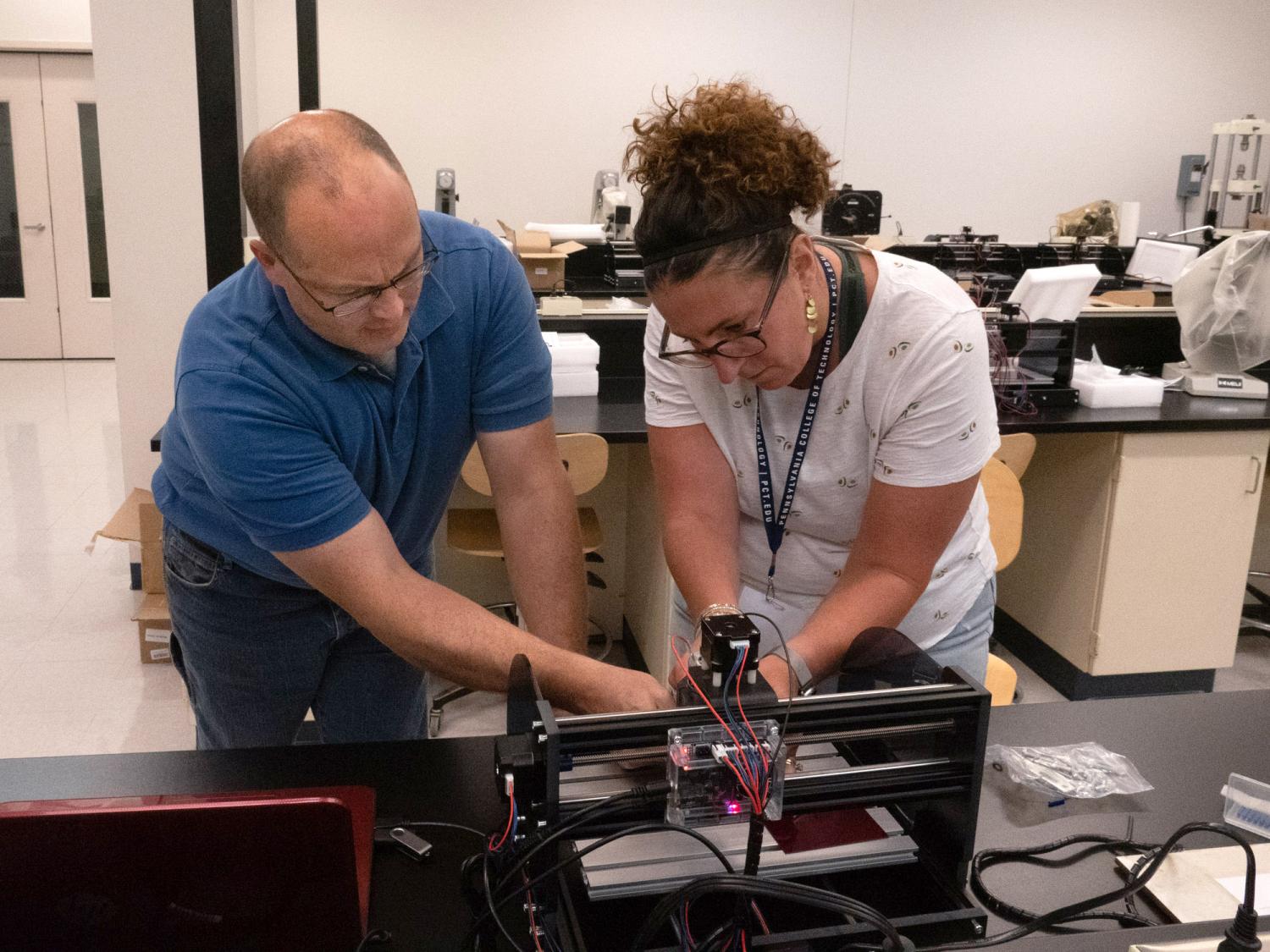 Paul W. Albright and Suzanne Mayberry working together on a small machine -- Penn College