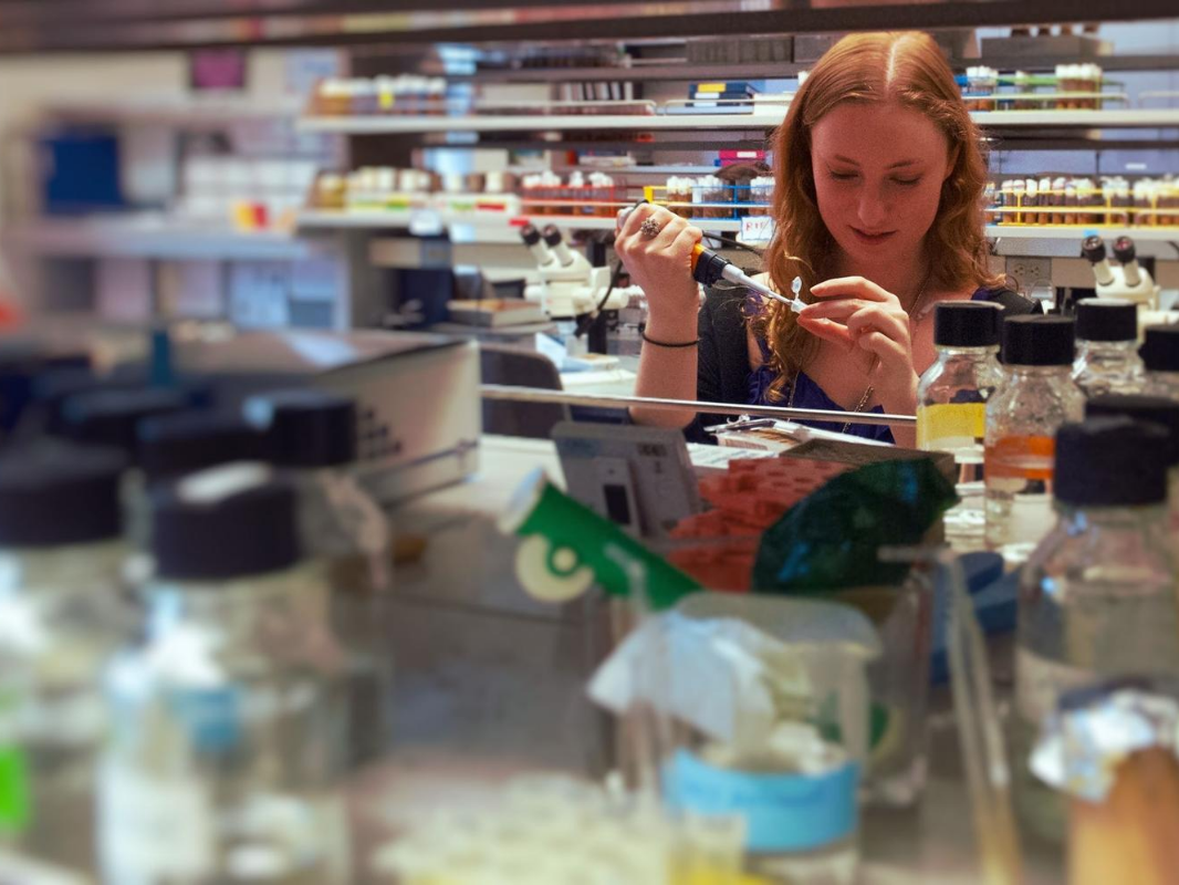 Woman working with test tubes in a research lab setting