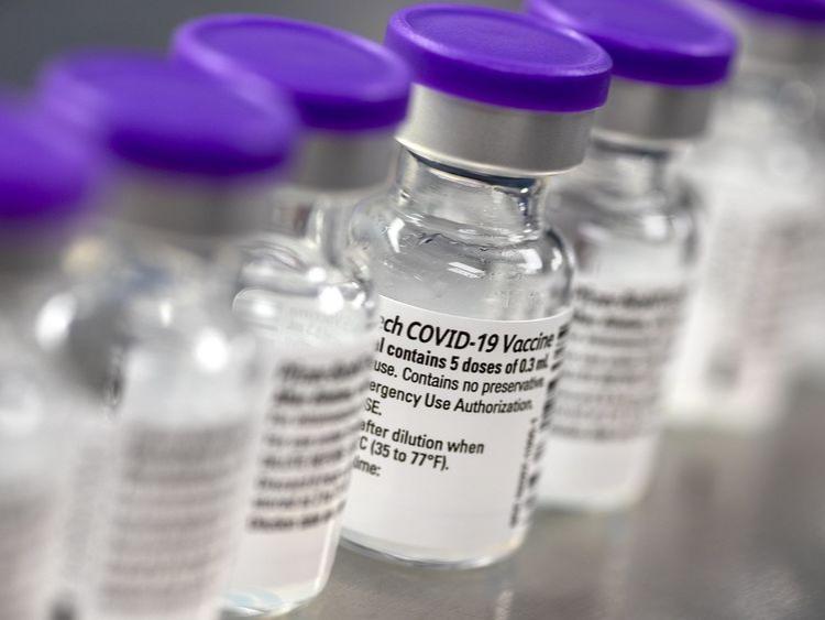 A row of vials containing COVID-19 vaccine.