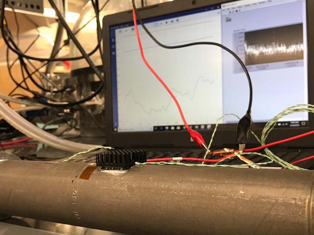 A thermoelectric device converts wasted heat from hot water pipes into electrical current 