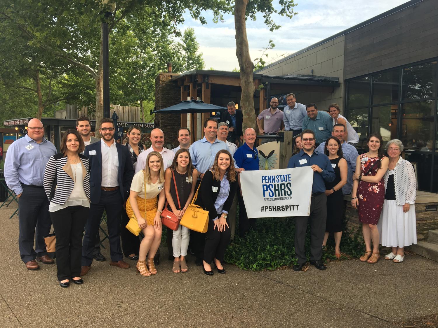 Alumni pose outside a restaurant in Pittsburgh