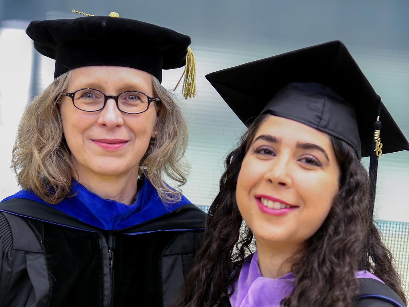 Ute Poerschke, at left, and a student in graduation garb.