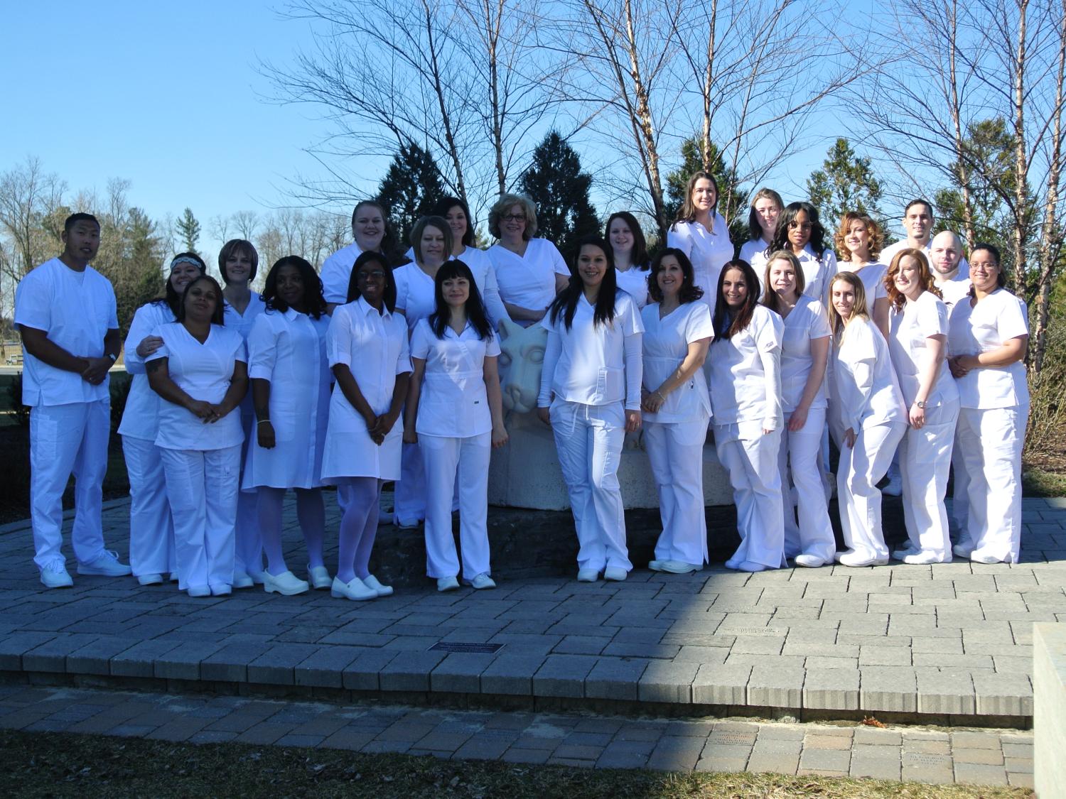 Group of LPN graduations near lion shrine