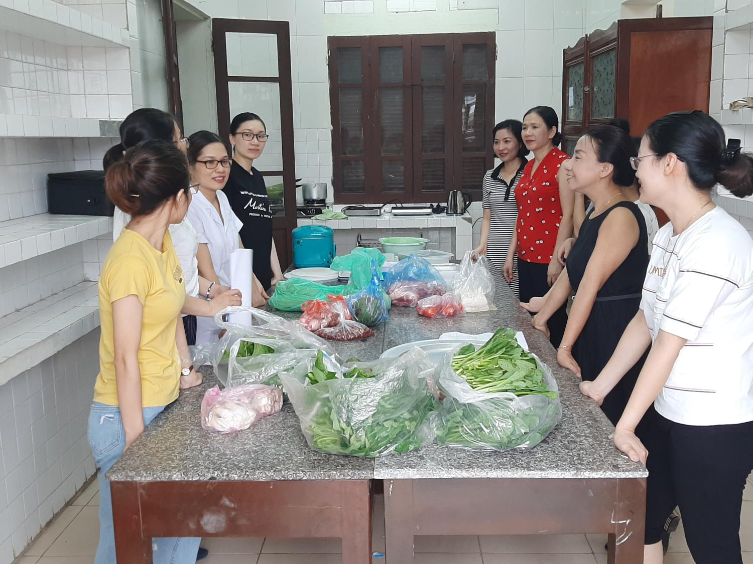 A group of women stands around a table with food