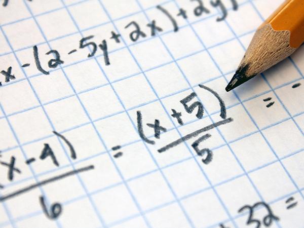 A piece of paper with math problems written in pencil.
