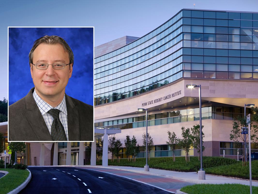 A head and shoulders professional portrait of George-Lucian Moldovan against a background image of Penn State Cancer Institute