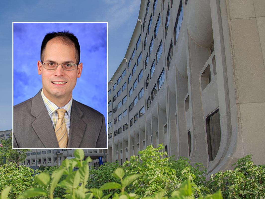 A head and shoulders professional portrait of William Calo against a background image of Penn State College of Medicine. 