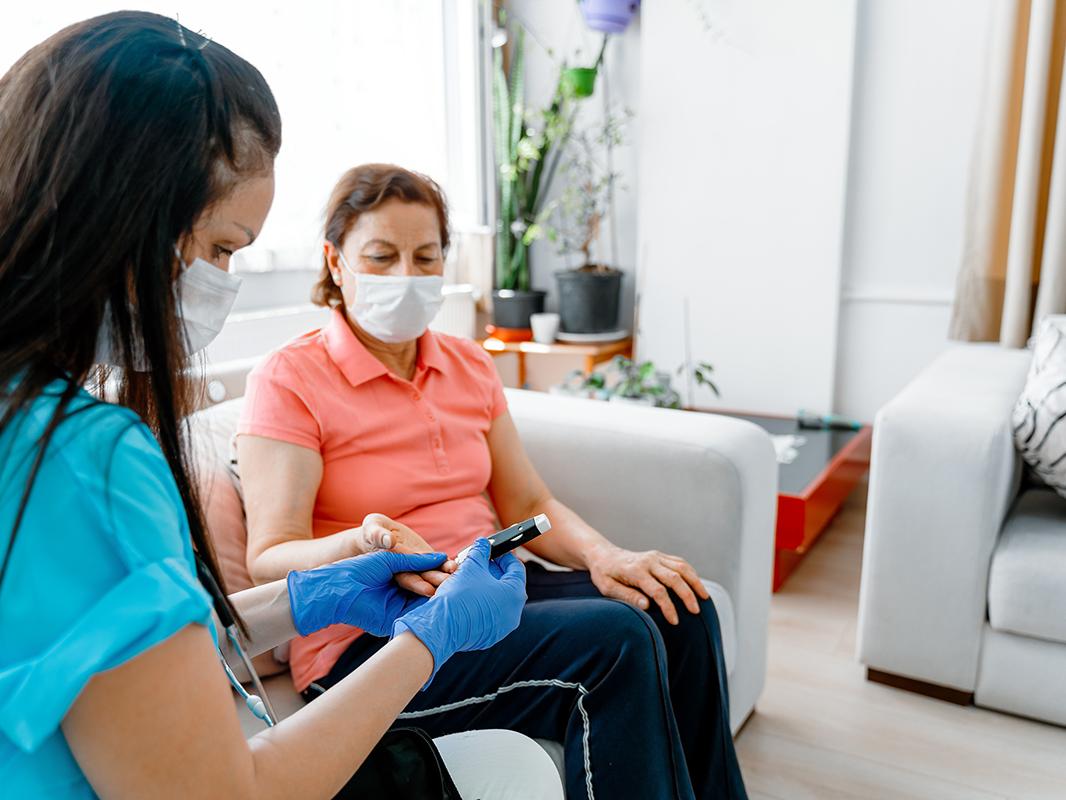 A nurse takes care of a patient with diabetes in the patient's home. 