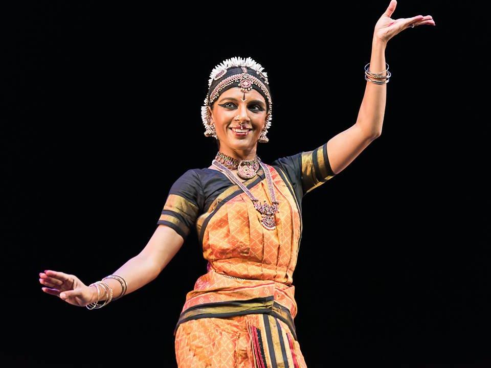 Ragamala Dance Company co-founder Aparna Ramaswamy, wearing an ethnic costume of intricate design, curves her hands during an Indian classical dance performance.