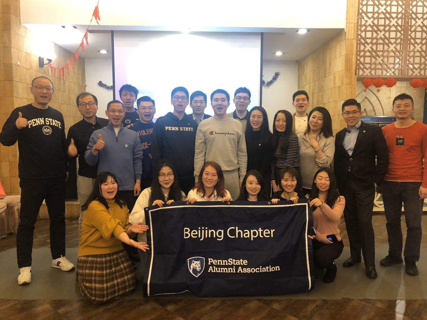 A group of Chinese alumni pose for a picture with a Penn State banner