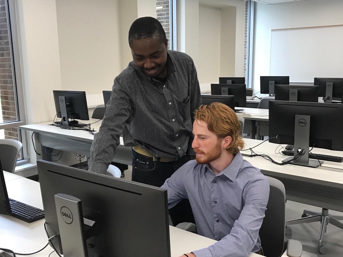 Richard Lomotey points to a computer as Evan McStay looks on.